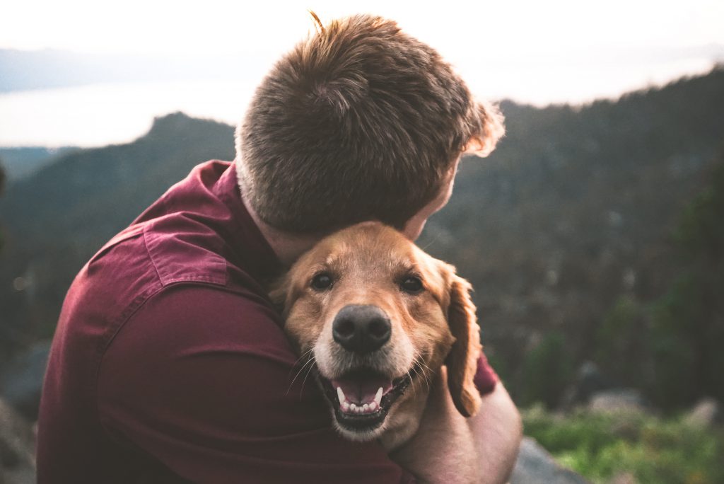 Men hugging his happy dog