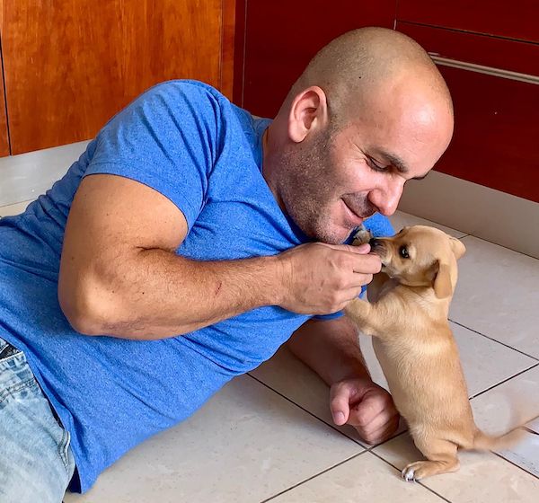 Shai Retzer dog trainer playing with puppy